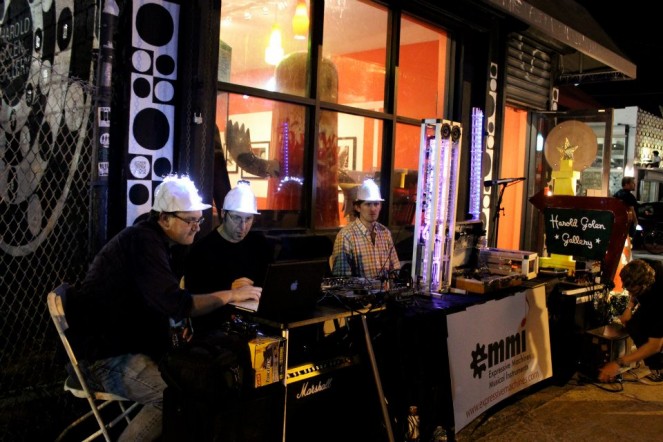 Troy Rogers with Expressive Machines Musical Instruments (EMMI) at Art Basel Miami, 2012. With composer-collaborators Steven Kemper (left) and Scott Barton (right) as well as various robotic musical instruments created by Expressive Machines.